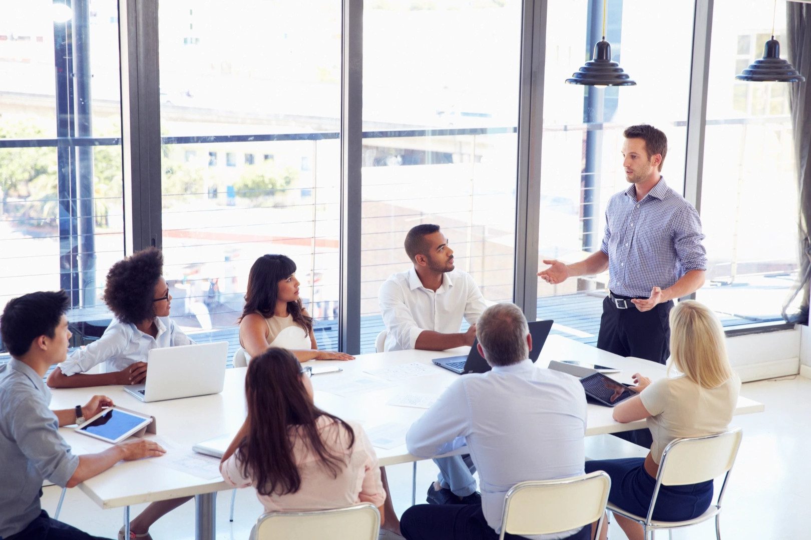 A standing man, planning with his co-workers